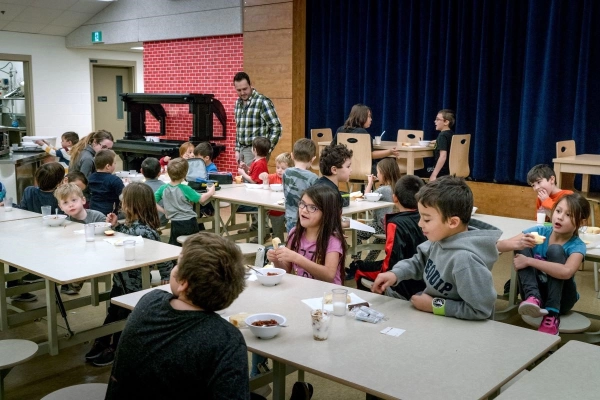 Children enjoy their school lunch meal at a school.