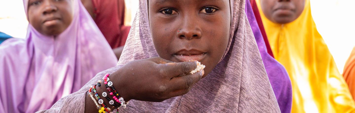 A young girl enjoying her school meal 