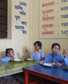  some children from Nepal share a meal cooked for them in school