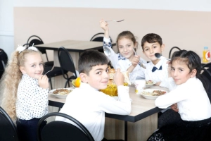 Children at a school in Armenia happily pose for the camera while enjoying their lunch meal of buckwheat and cabbage salad. SIFI/Tigran Arakelyan